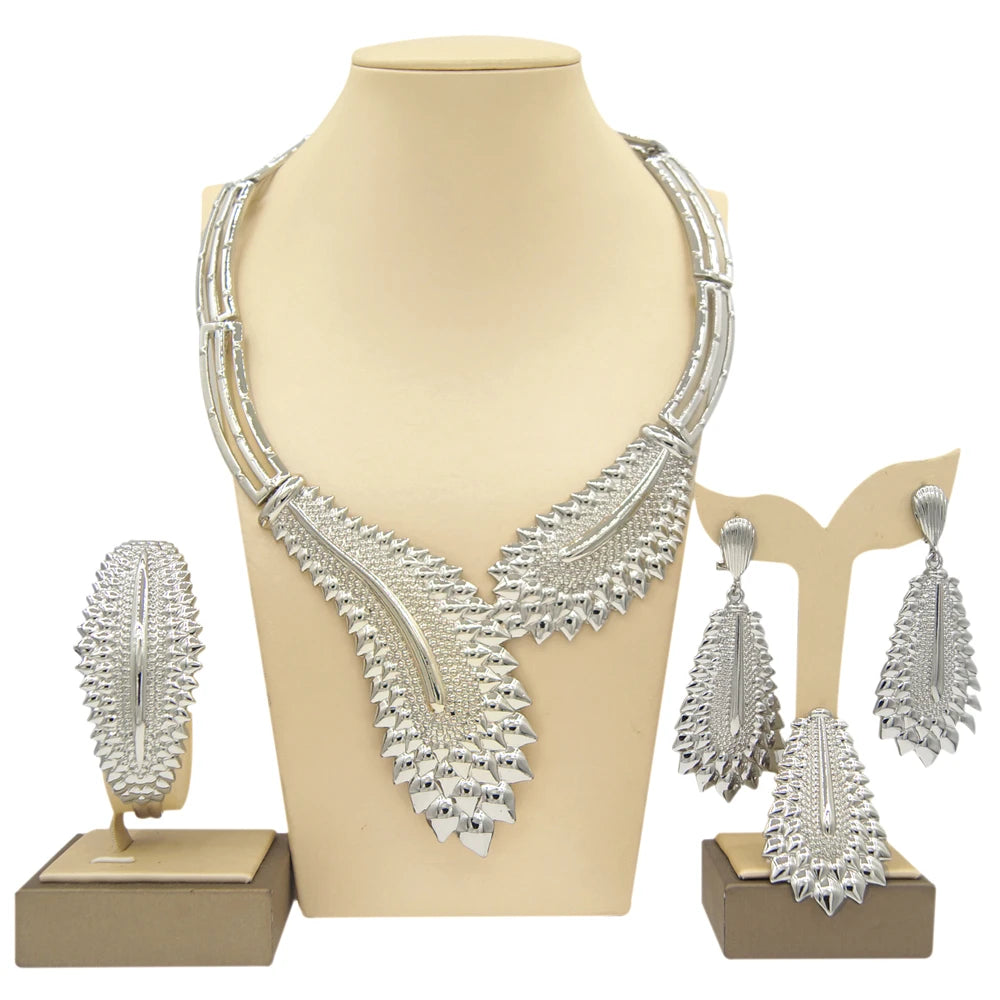 Gold plated Dubai jewelry set by LAQTA featuring intricate designs and matching earrings on a display stand