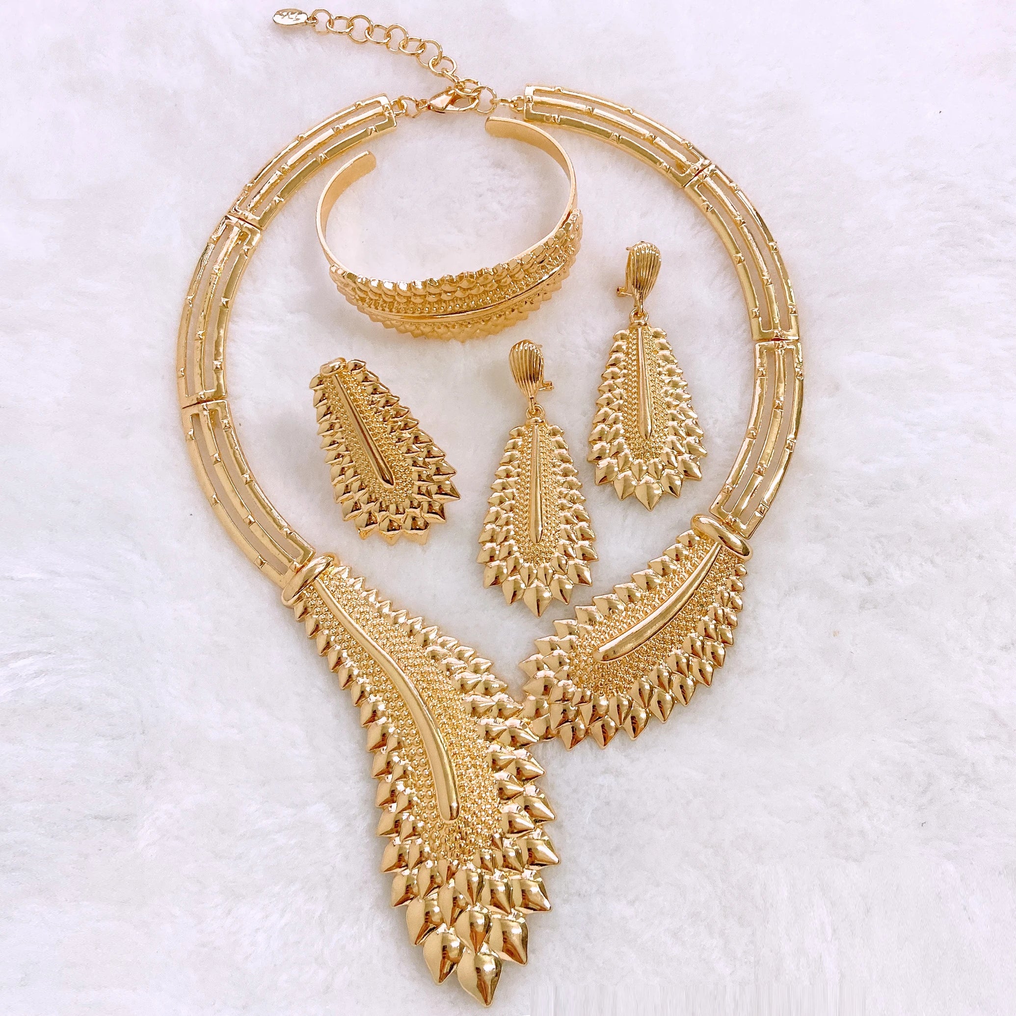 Gold plated Dubai jewelry set by LAQTA featuring intricate designs with necklaces, earrings, and matching accessories.