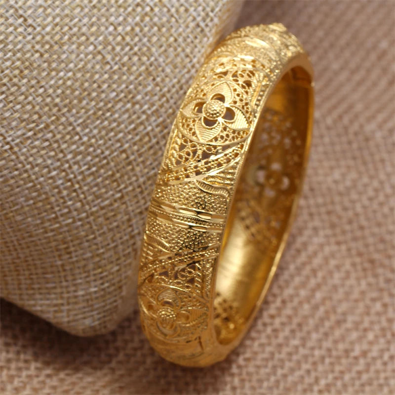 HD image of LAQTA 24k Dubai gold color bangles showing intricate design and shiny gold finish on a white background.