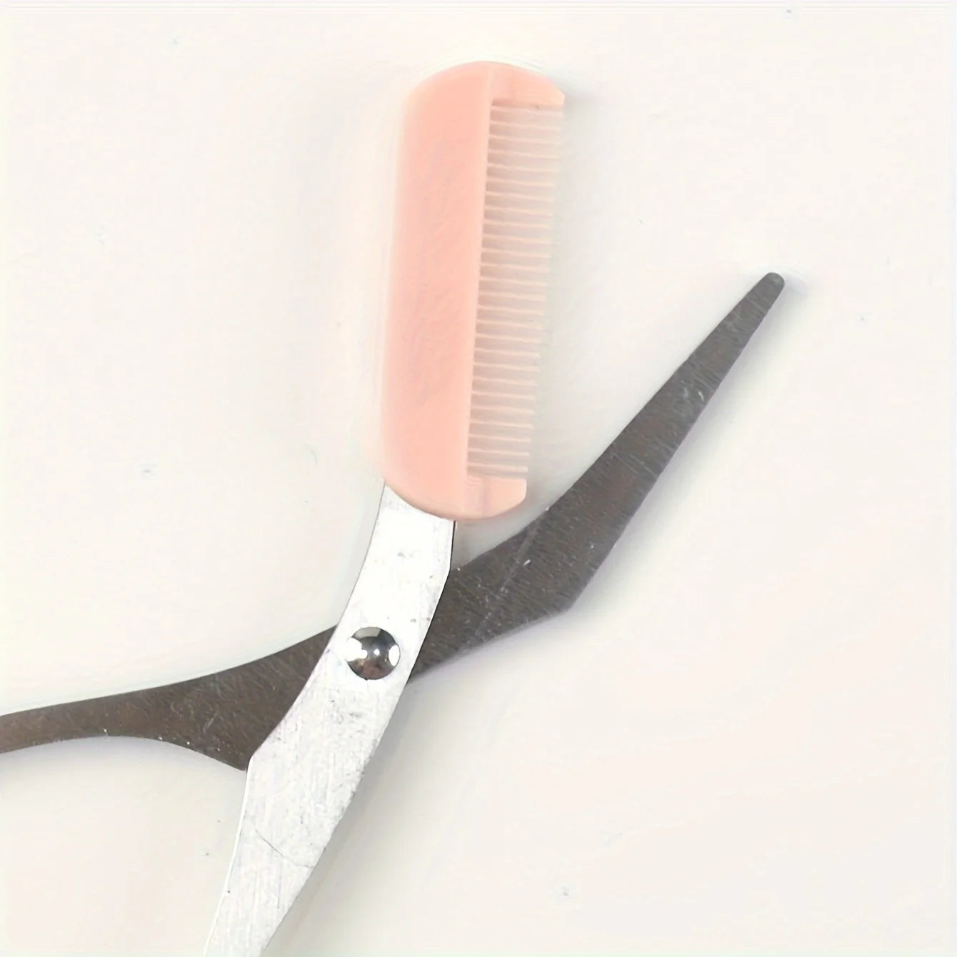 Pink eyebrow trimming scissors by LAQTA with sharp blades and ergonomic handles, ideal for precise eyebrow grooming.