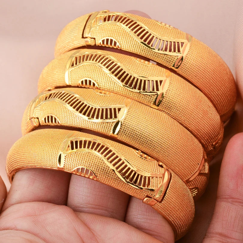 Elegant 24k Dubai gold color bangles by LAQTA, showcasing shiny, traditional gold jewelry with intricate design details.