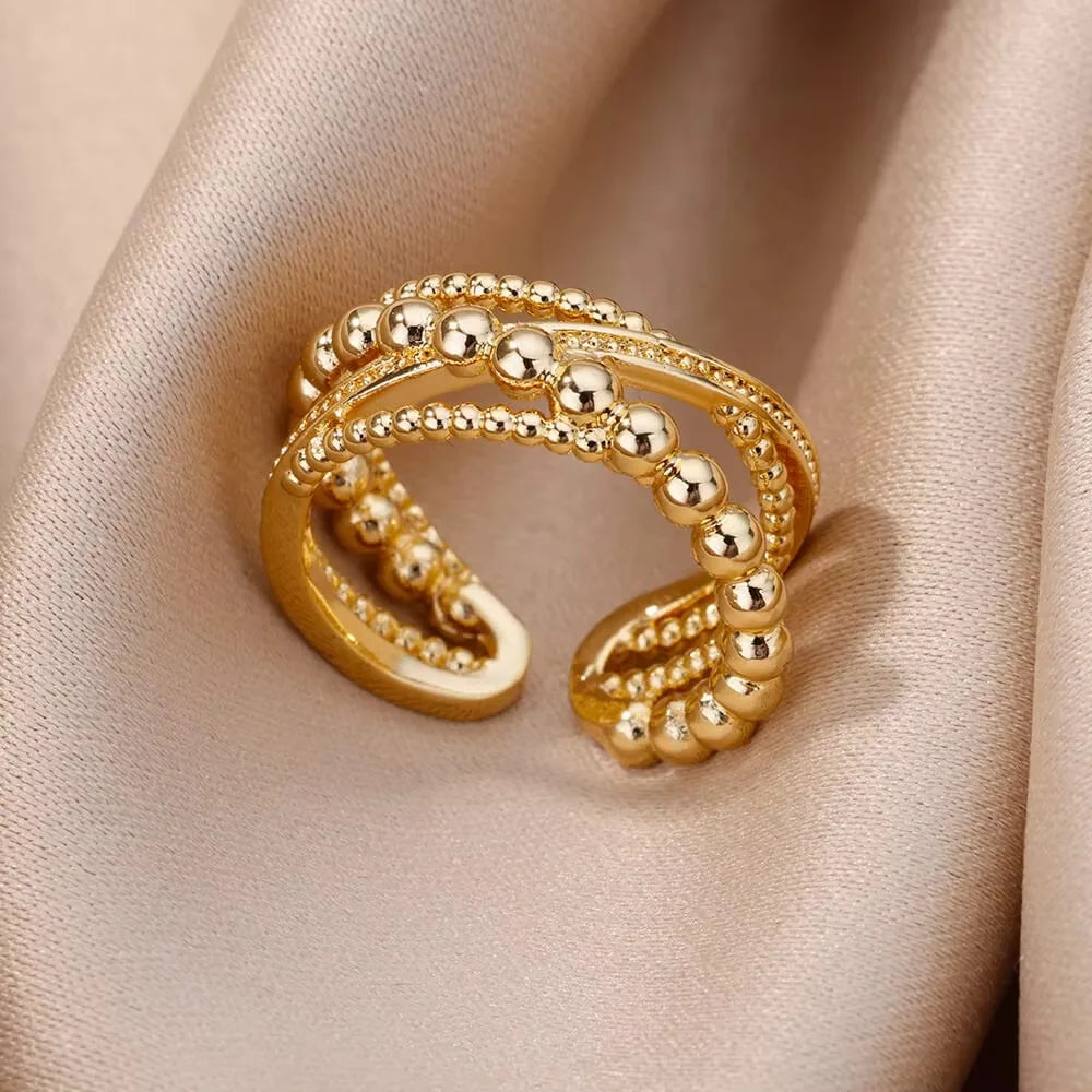 Elegant women's rings by LAQTA featuring intricate designs and shiny finishes, displayed in a close-up shot.