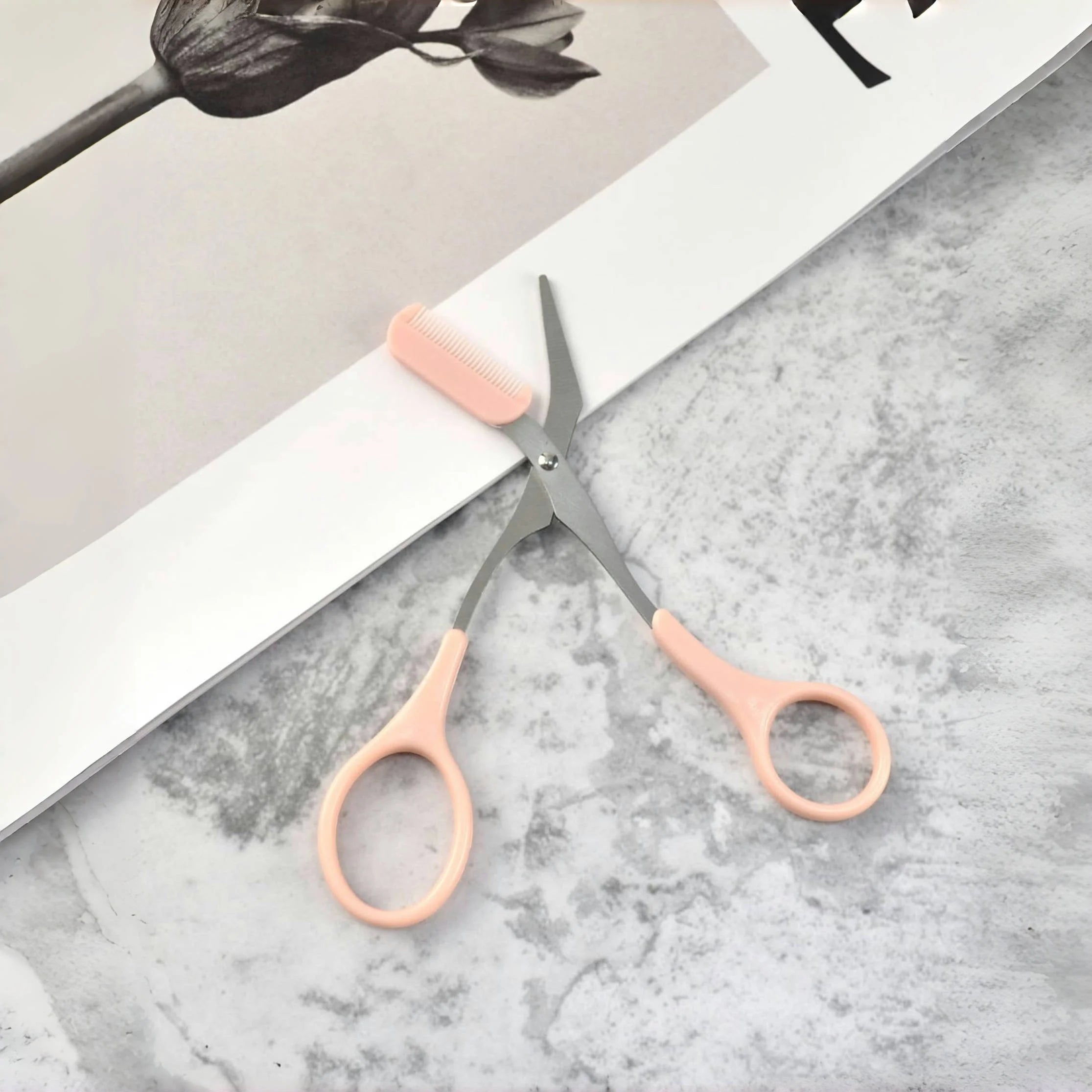 Pink eyebrow trimming scissors by LAQTA with sharp blades and ergonomic handles for precise eyebrow grooming.