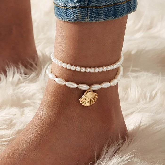 Close-up of LAQTA metal pendant anklet with intricate design, showcasing detailed craftsmanship and shiny silver finish.