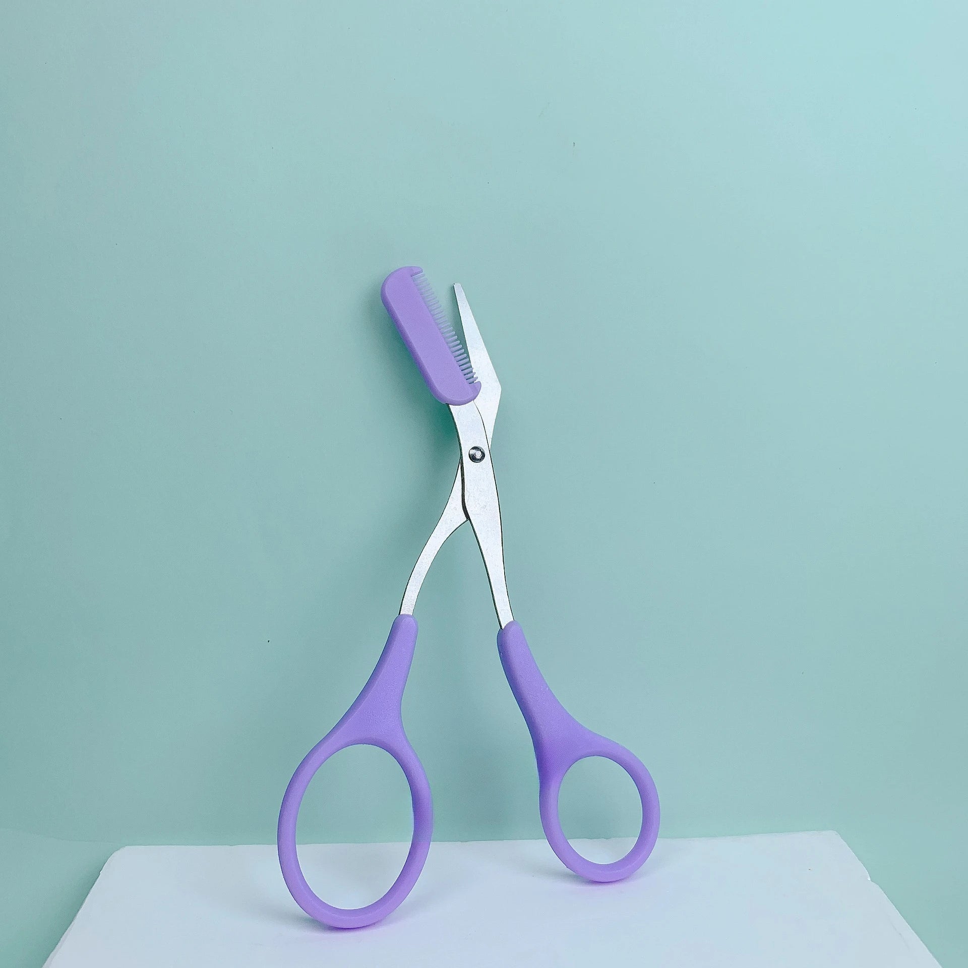 Pink eyebrow trimming scissors by LAQTA with sharp blades, designed for precise eyebrow shaping and grooming.