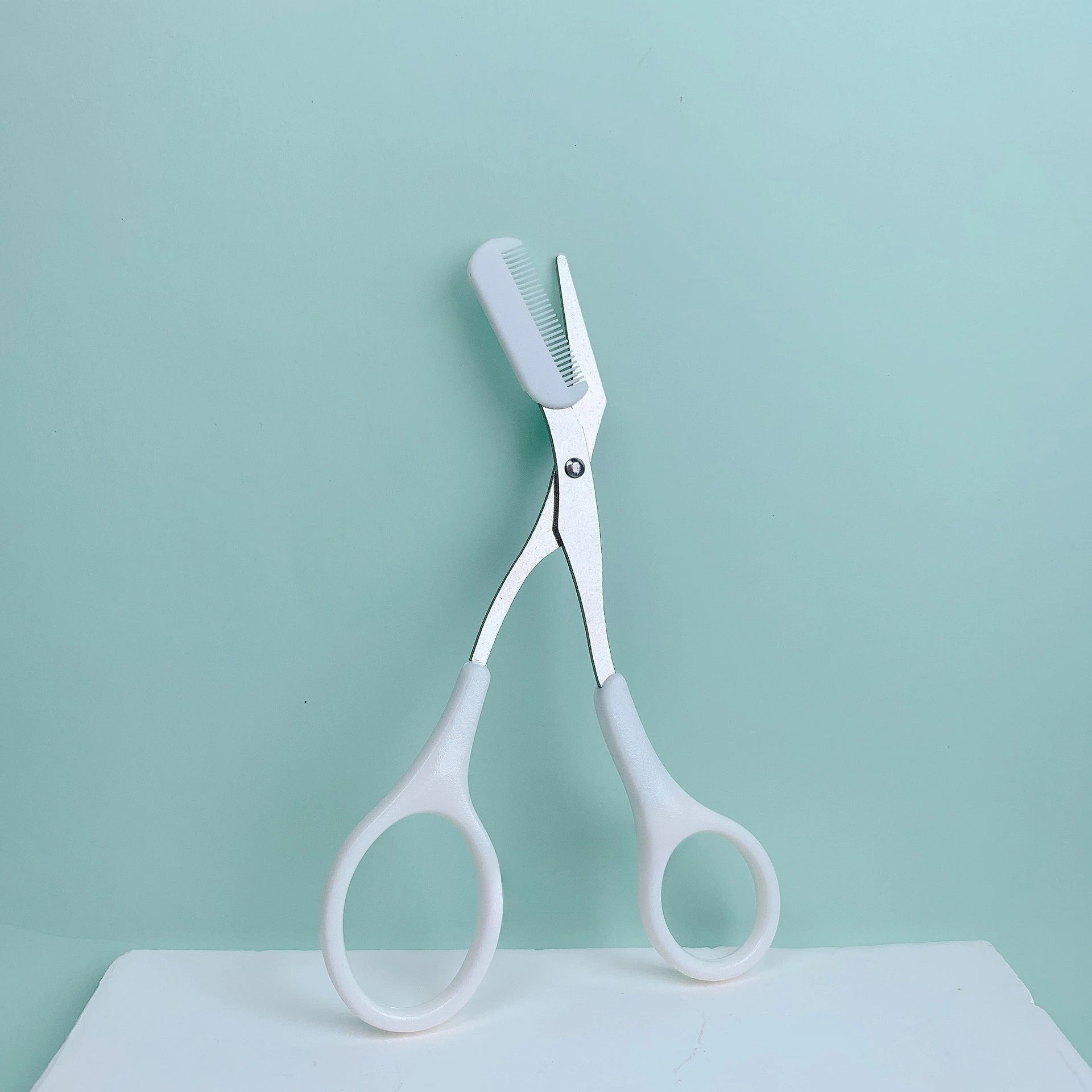 Pink eyebrow trimming scissors by LAQTA with sharp, precise blades for grooming eyebrows.
