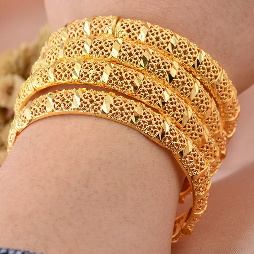 24k Dubai gold color bangles by LAQTA, featuring shiny gold finish and traditional design, displayed in a close-up shot.