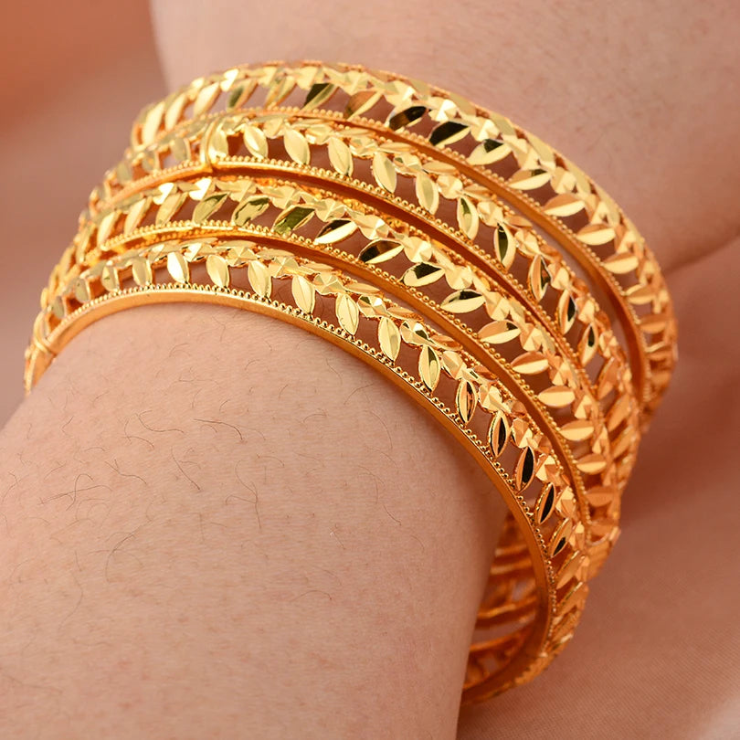 Elegant 24k Dubai gold color bangles by LAQTA, featuring intricate design and shiny gold finish on a white background.