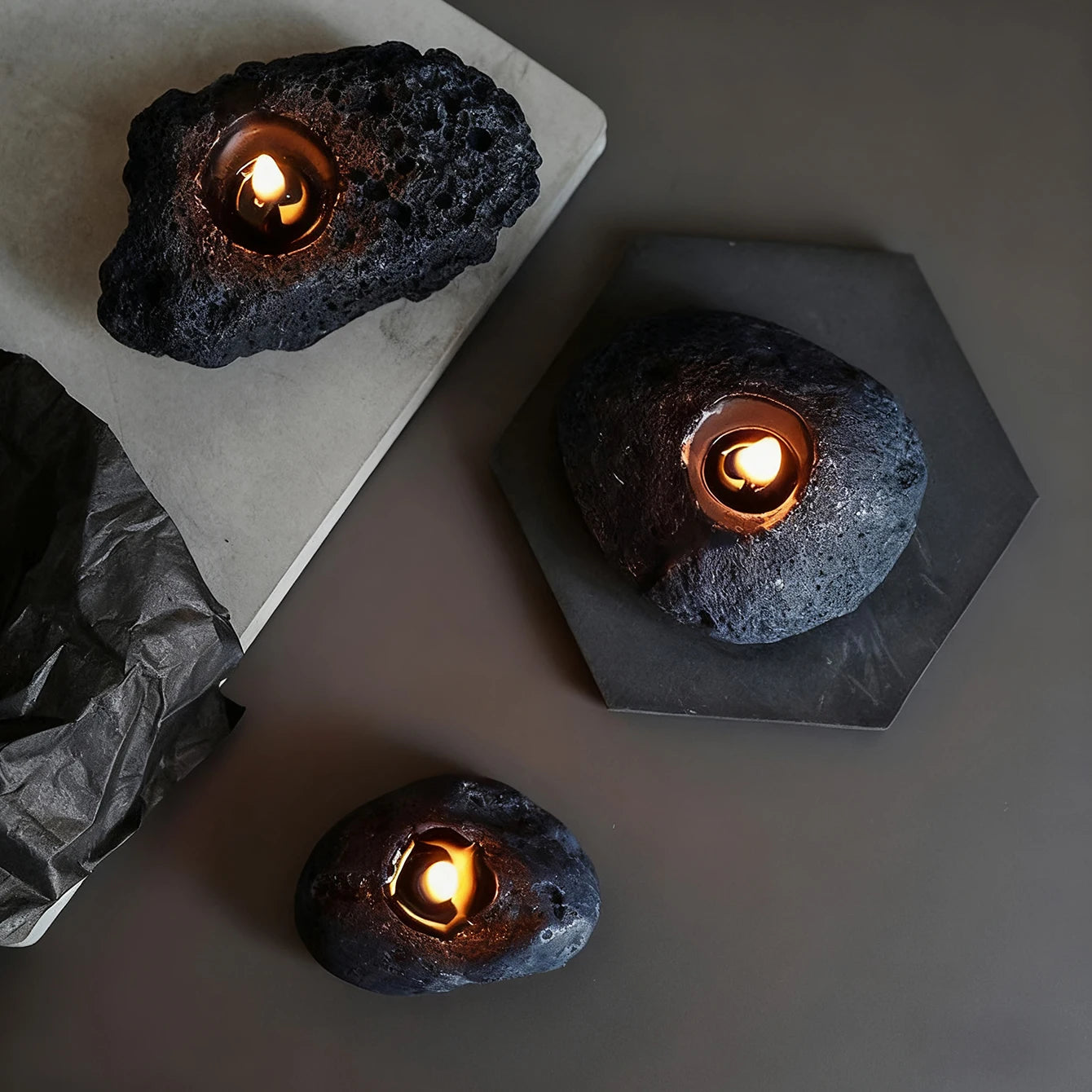 LAQTA Meteorite scented candle with a sleek glass container and minimalist design, emitting a warm, inviting glow.