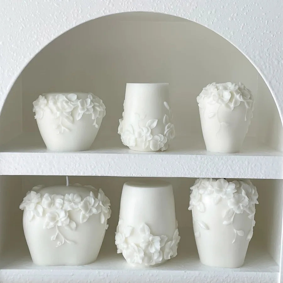 Nordic floral scented candle by LAQTA in a glass jar with a lit wick, showcasing a floral design on the label.
