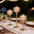 Elegant gold and silver metal glass candle by LAQTA with intricate design and warm glow.